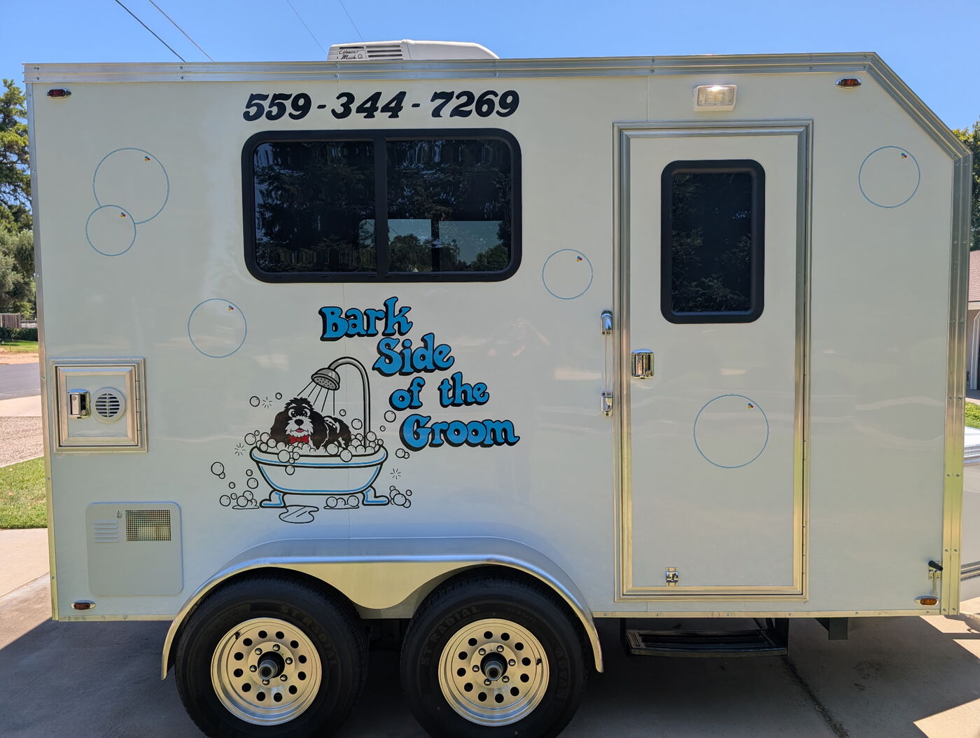 The Bark Side of the Groom mobile grooming trailer, branded with the logo and phone number